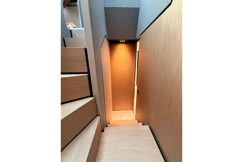  Yacht Photos Pics Interior staircase of 2020 Ferretti Yachts 720, featuring modern wood design and ambient lighting.