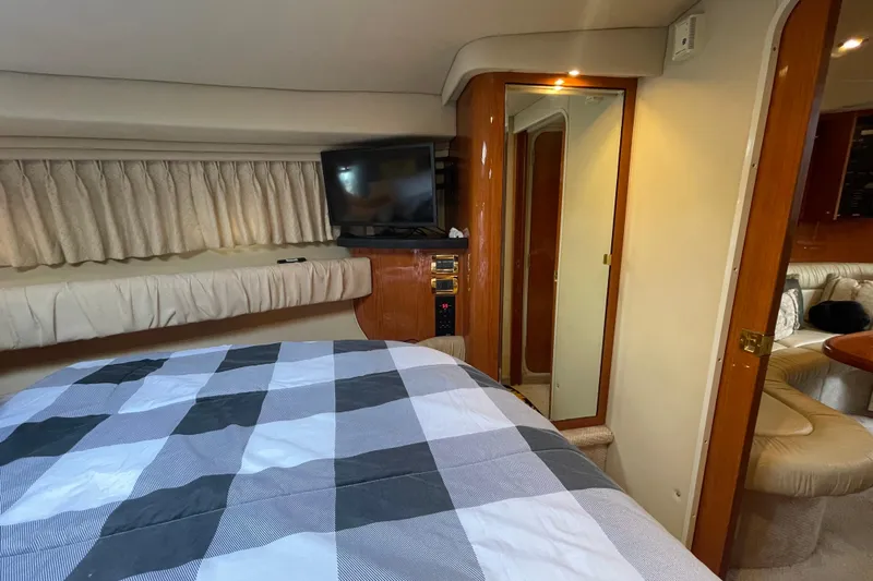 Priorities Yacht Photos Pics Interior of 1999 Sea Ray 380 Sundancer with bed, TV, and wood accents.