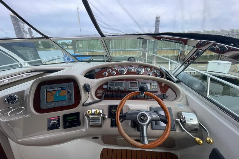 Priorities Yacht Photos Pics 1999 Sea Ray 380 Sundancer helm with navigation equipment and wooden steering wheel.