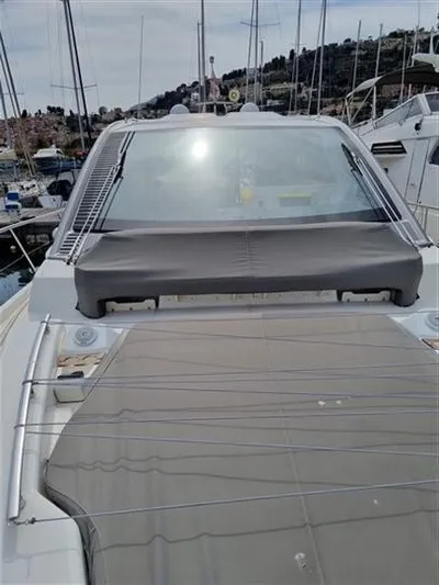  Yacht Photos Pics 2019 Cranchi 60HT yacht with covered windshield, docked in a marina.