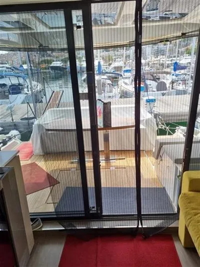  Yacht Photos Pics 2019 Cranchi 60HT yacht interior with marina view through sliding glass doors.