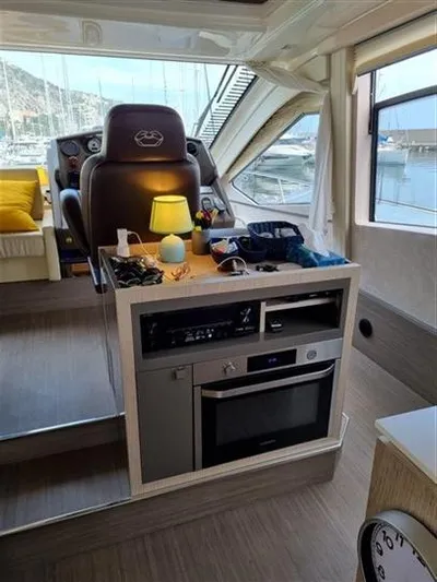  Yacht Photos Pics Interior of 2019 Cranchi 60HT yacht with helm, appliances, and scenic marina view.