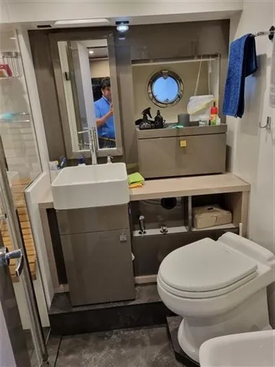  Yacht Photos Pics 2019 Cranchi 60HT yacht bathroom with modern fixtures and porthole window.