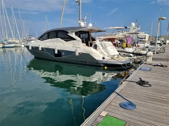  Yacht Photos Pics 2019 Cranchi 60HT yacht docked at a marina, reflecting on calm water.