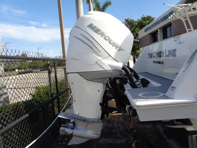  Yacht Photos Pics 2022 Contender 32 ST boat with Mercury outboard engine, docked near a fence.