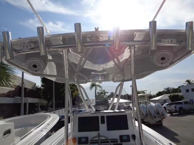  Yacht Photos Pics 2022 Contender 32 ST boat helm with rod holders and electronics under sunny sky.