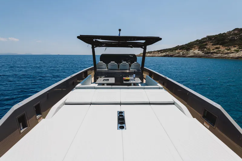  Yacht Photos Pics 2023 De Antonio Yachts D42 Open cruising on clear blue waters, featuring spacious deck seating.