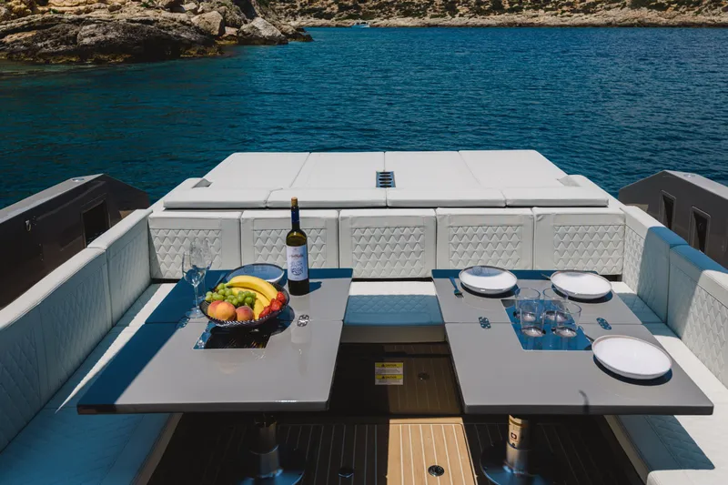  Yacht Photos Pics Luxury dining setup on 2023 De Antonio Yachts D42 Open, overlooking serene waters.