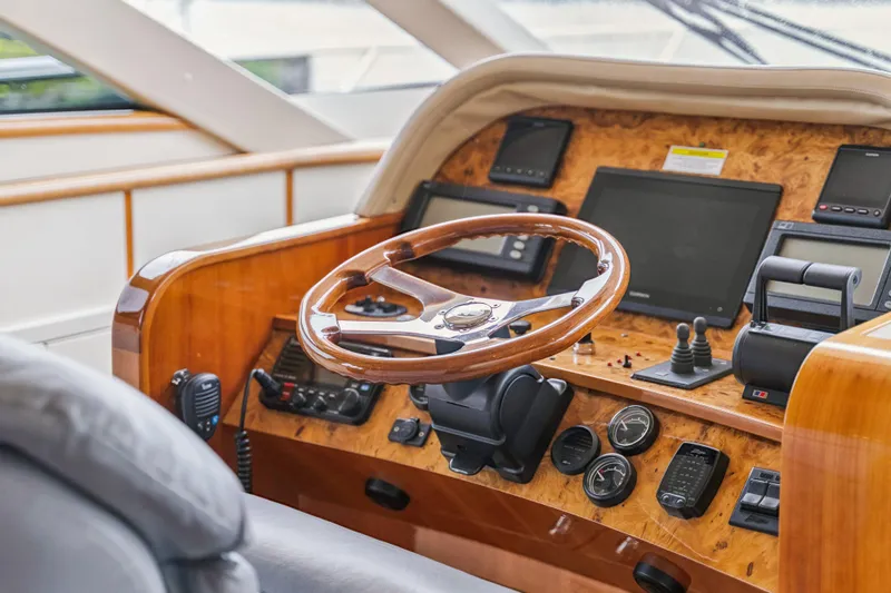 Day To Day Yacht Photos Pics Cockpit of 2008 Neptunus 62 Flybridge yacht with wooden steering wheel and navigation instruments.