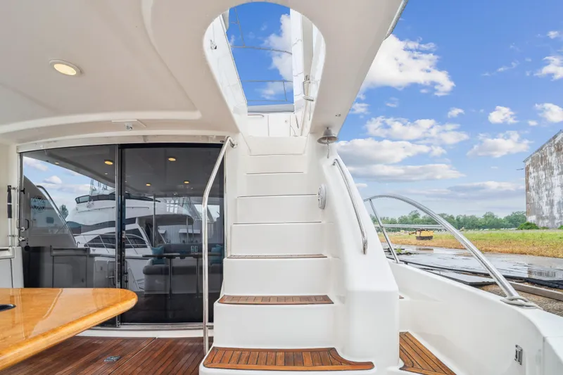 Day To Day Yacht Photos Pics 2008 Neptunus 62 Flybridge yacht with elegant staircase and outdoor seating area.