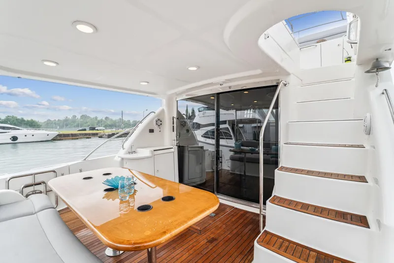 Day To Day Yacht Photos Pics Luxurious 2008 Neptunus 62 Flybridge yacht with elegant outdoor seating and staircase.