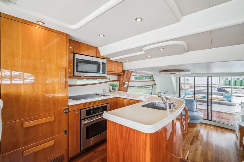 Day To Day Yacht Photos Pics Luxurious 2008 Neptunus 62 Flybridge yacht kitchen with modern appliances and sleek wood finishes.