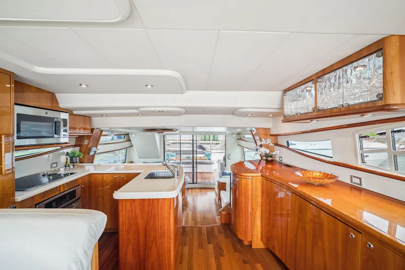 Day To Day Yacht Photos Pics Luxurious interior of 2008 Neptunus 62 Flybridge yacht with modern kitchen and elegant wood finishes.