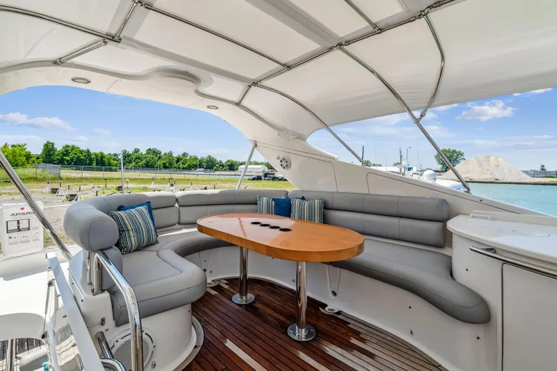 Day To Day Yacht Photos Pics Luxurious 2008 Neptunus 62 Flybridge yacht with elegant seating and scenic waterfront view.