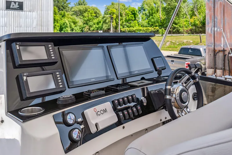 Day To Day Yacht Photos Pics Helm of 2008 Neptunus 62 Flybridge with modern navigation equipment and steering wheel.