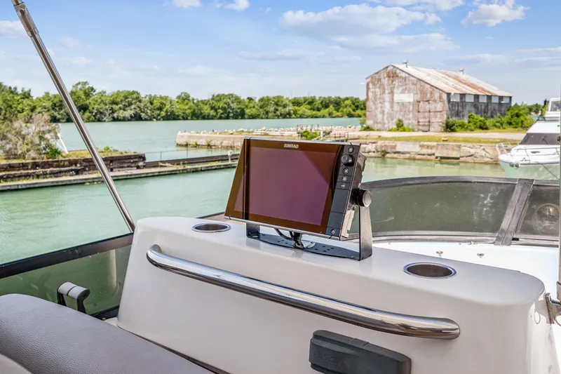 Day To Day Yacht Photos Pics Flybridge of 2008 Neptunus 62 yacht with navigation system, overlooking serene waterway.