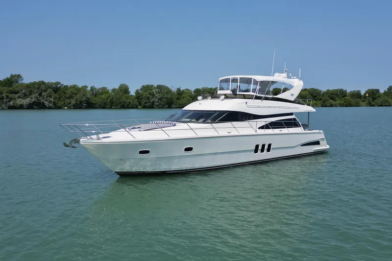 Day To Day Yacht Photos Pics 2008 Neptunus 62 Flybridge yacht cruising on a serene lake under clear skies.