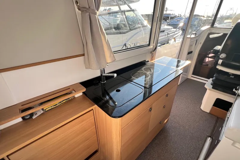  Yacht Photos Pics Modern kitchen area in 2025 Nimbus C11 boat with sleek black countertop.