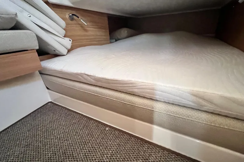  Yacht Photos Pics Cozy sleeping area in 2025 Nimbus C11 boat with comfortable mattress and wooden accents.
