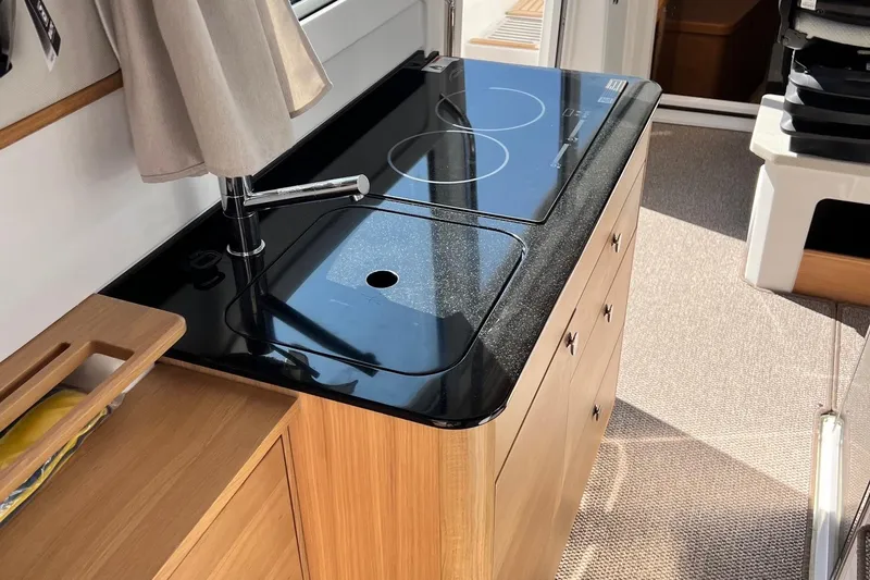  Yacht Photos Pics Modern kitchen area in 2025 Nimbus C11 boat with sleek black countertop and stove.