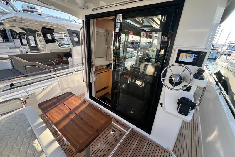  Yacht Photos Pics 2025 Nimbus C11 boat interior with wooden table, steering wheel, and navigation system.