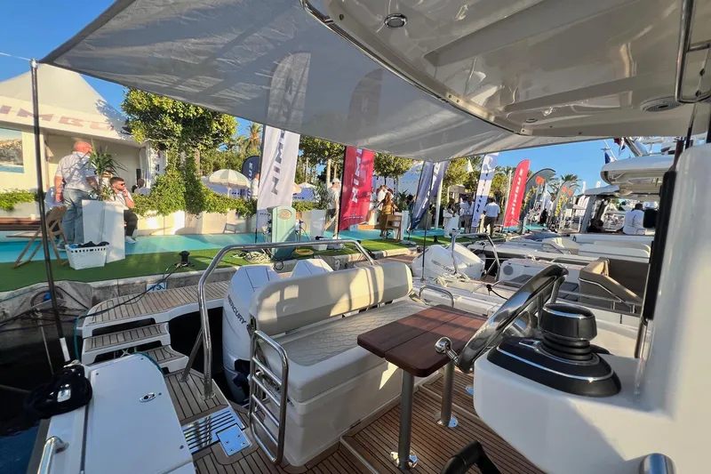  Yacht Photos Pics 2025 Nimbus C11 boat interior at a vibrant outdoor exhibition with people and banners.