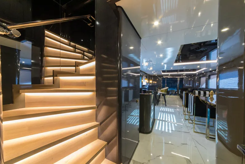 Queen Karina Yacht Photos Pics Luxurious interior of a 2000 Cheoy Lee 92 ft yacht with modern staircase and elegant furnishings.