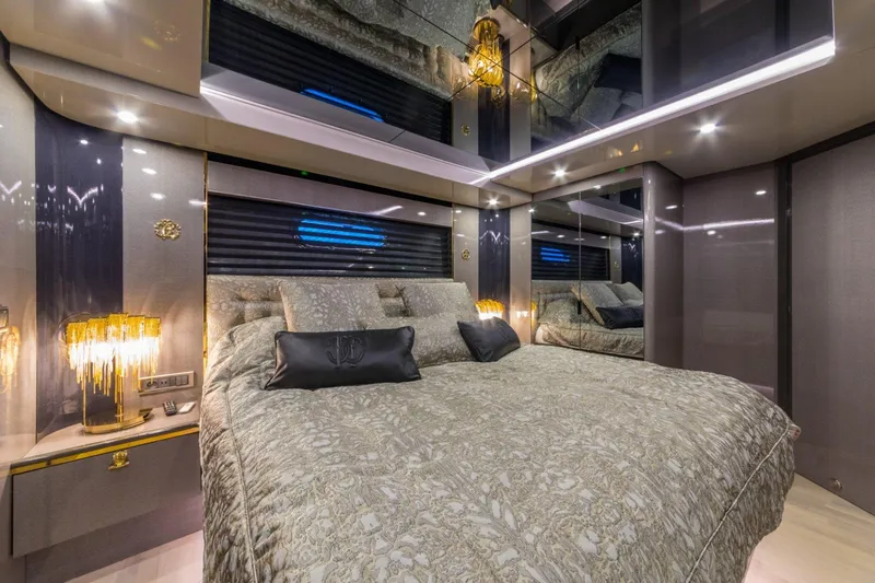 Queen Karina Yacht Photos Pics Luxurious bedroom interior on a 2000 Cheoy Lee 92 ft yacht, featuring elegant lighting and decor.