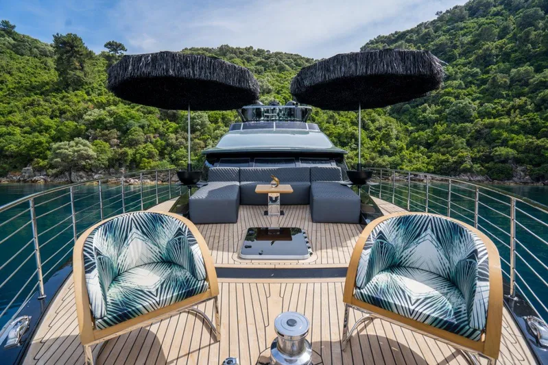 Queen Karina Yacht Photos Pics Luxurious 2000 Cheoy Lee 92 ft yacht deck with stylish seating and scenic greenery backdrop.