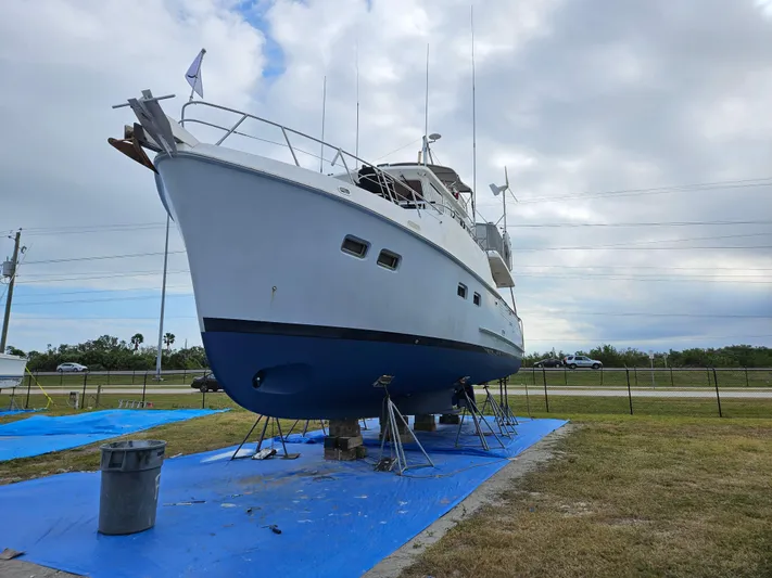 Off The Grid Yacht Photos Pics 2001 Selene Ocean Trawler on land, blue tarp, overcast sky.