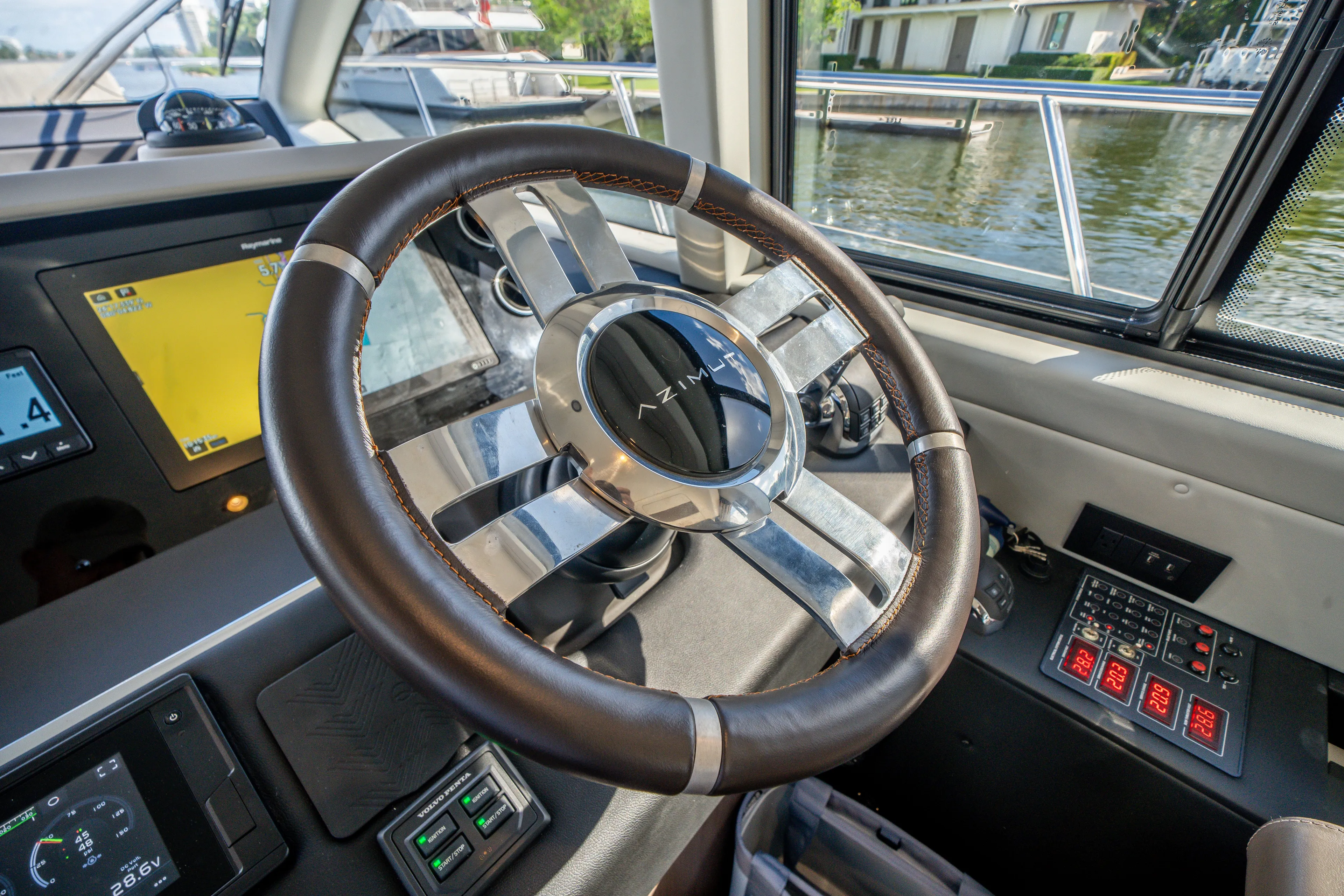  Yacht Photos Pics Steering wheel of 2022 Azimut 50 Fly yacht, featuring modern dashboard controls.