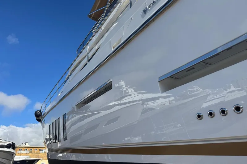  Yacht Photos Pics 2015 Fairline Squadron 65 yacht reflecting in water, showcasing sleek design and luxury features.