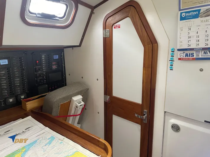 Rubicon Yacht Photos Pics Cozy interior of 2022 Radford 15.2 sailboat with navigation station and wooden door.