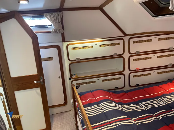 Rubicon Yacht Photos Pics Cozy cabin interior of 2022 Radford 15.2 yacht with striped bedding and wooden accents.