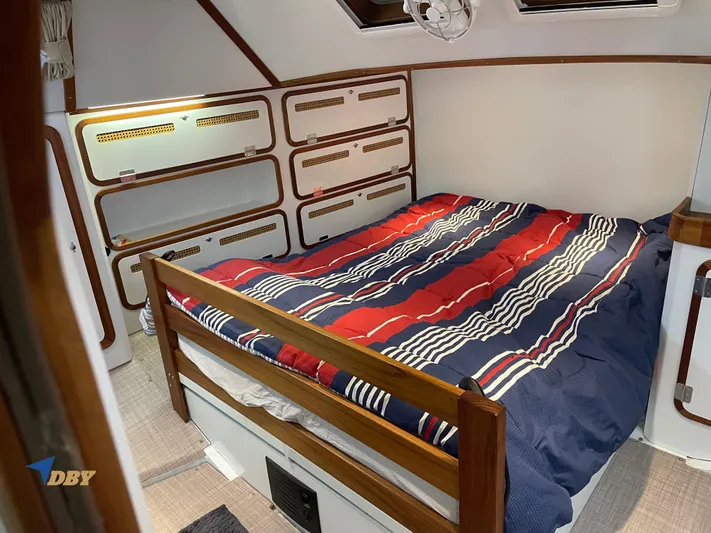 Rubicon Yacht Photos Pics Cozy cabin interior of 2022 Radford 15.2 with striped bedding and wooden accents.