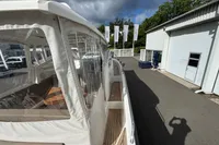 Nimbus W 9 boat, 2019 model, docked near a building under cloudy skies.