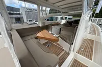 Interior of 2019 Nimbus W 9 boat with seating and wooden table, docked near Volvo building.