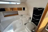 2019 Nimbus W 9 boat bathroom with toilet, sink, mirror, and storage pockets.