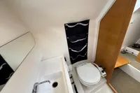 2019 Nimbus W 9 boat bathroom with sink, mirror, and compact toilet.
