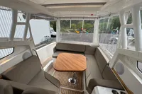 Interior of 2019 Nimbus W 9 boat with seating and wooden table.