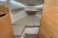 Cozy cabin interior of 2019 Nimbus W 9 boat with beige cushions and wooden accents.