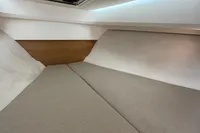 Interior cabin of 2019 Nimbus W 9 boat with beige cushions and wooden accents.
