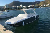 2019 Regal 26 FasDeck boat docked in a scenic marina with mountains in the background.