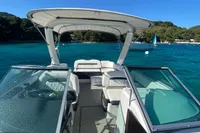 2019 Regal 26 FasDeck boat on clear blue water, featuring spacious seating and canopy.