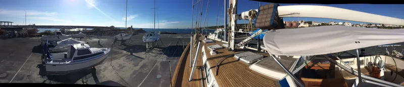 Challenger Yacht Photos Pics Panoramic view of a 1992 Hallberg-Rassy 45 yacht docked at a marina under clear skies.