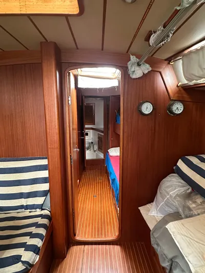 Challenger Yacht Photos Pics Interior of 1992 Hallberg-Rassy 45 yacht with wood paneling and striped seating.