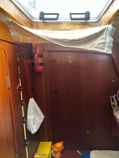 Challenger Yacht Photos Pics Interior of a 1992 Hallberg-Rassy 45 sailboat cabin with wooden paneling and nautical decor.