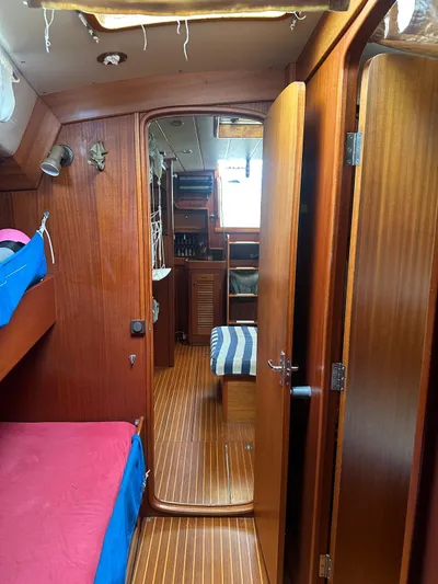 Challenger Yacht Photos Pics Interior of 1992 Hallberg-Rassy 45 yacht, featuring wooden paneling and cozy cabin space.