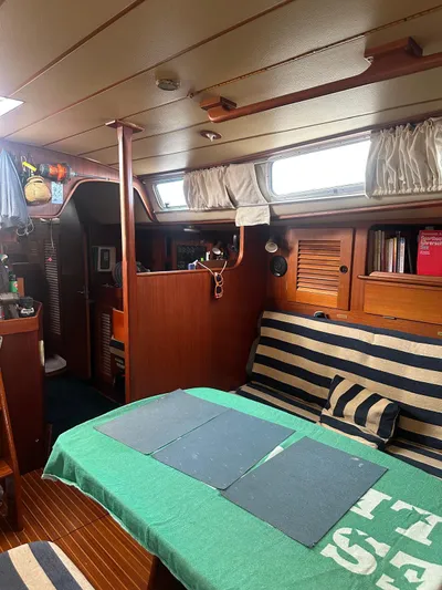 Challenger Yacht Photos Pics Interior of a 1992 Hallberg-Rassy 45 sailboat with striped seating and wooden finishes.