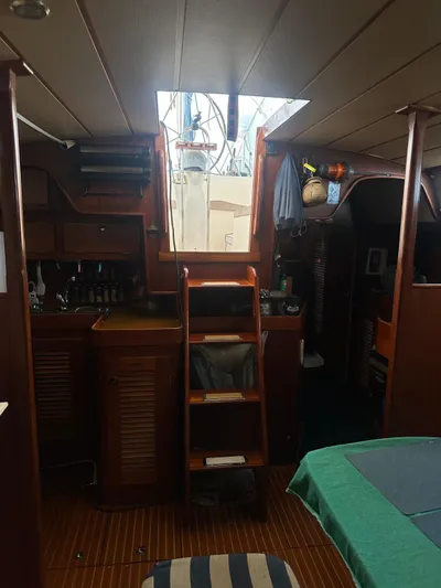 Challenger Yacht Photos Pics Interior of a 1992 Hallberg-Rassy 45 sailboat, featuring wooden cabinetry and a central staircase.